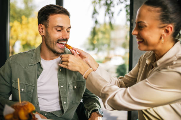 istock Cute couple feeding each other in a restaurant. 2182896216