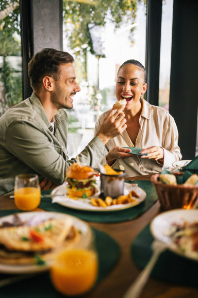 istock Cute couple feeding each other in a restaurant. 2182896237