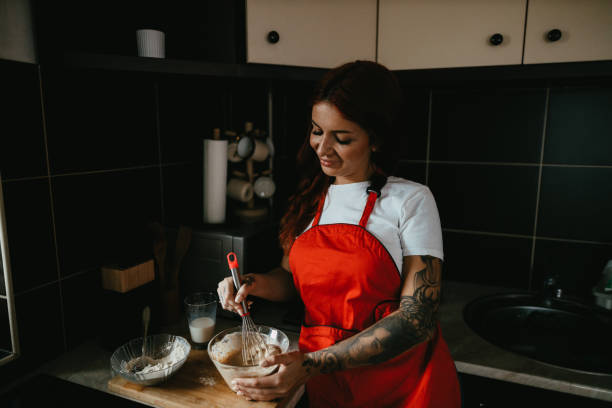 istock Smiling Young Woman Preparing Pancake Mix at Home 2182899719
