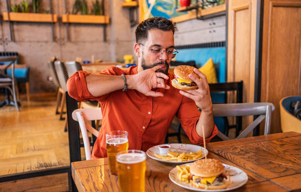 istock Young man enjoying a delicious burger 2182900051