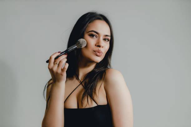 istock Young Woman Applying Blush Makeup 2182900234