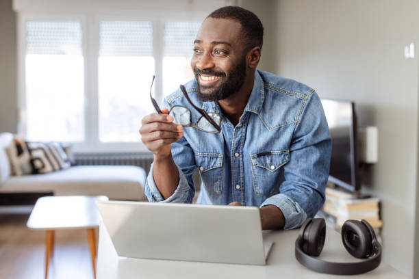 istock Portrait of a smiling man using a laptop at home 2182900607