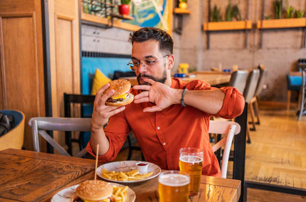 istock Young man enjoying a delicious burger 2182900977