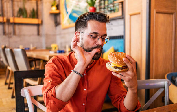 istock Young man enjoying a delicious burger 2182901117