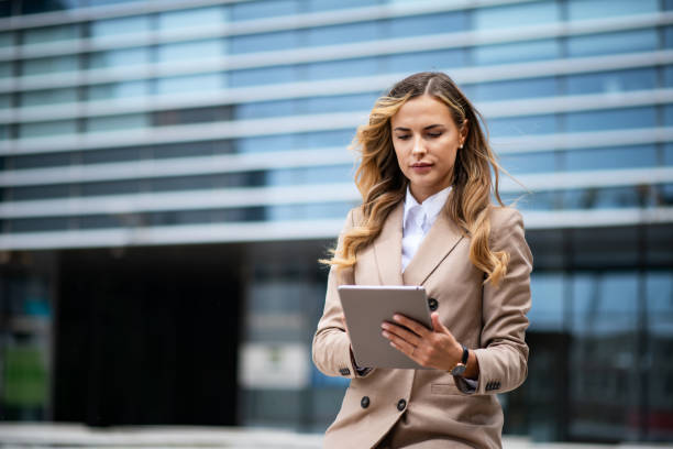istock Businesswoman using digital tablet in front of office building 2182903392