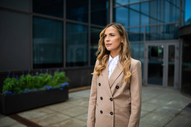 istock Businesswoman looking away while standing outside office building 2182903725