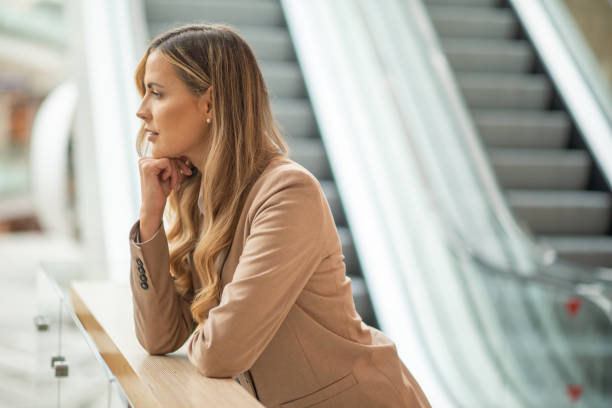istock Pensive businesswoman leaning on railing in modern building 2182905221