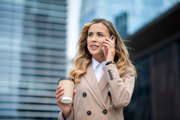 istock Businesswoman walking and talking on phone while holding coffee 2182905565