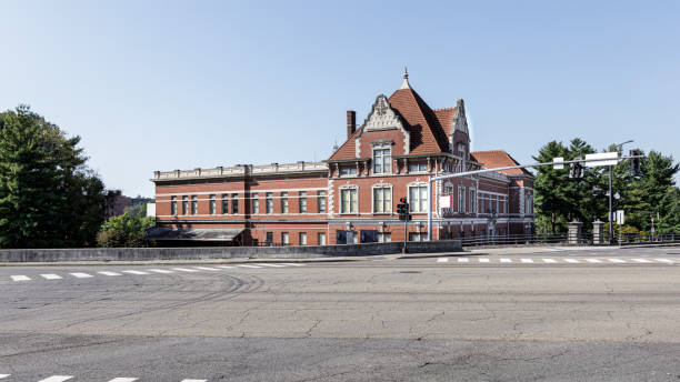 Fort Smith, Arkansas - USA, May 7, 2025. Railroad cars and old Frisco train station in Fort Smith Arkansas. Hopper cars on track next to old Frisco rail station. Now part of the class III railway Arkansas and Missouri line.