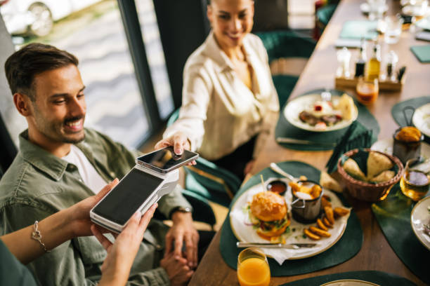 istock People paying with contactless credit card in a restaurant. 2182910779