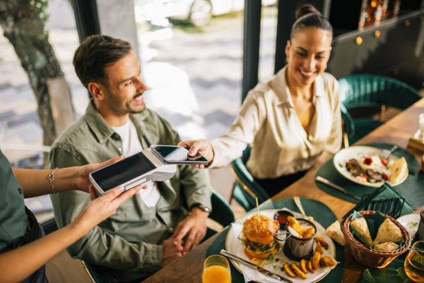 People paying with contactless credit card in a restaurant.