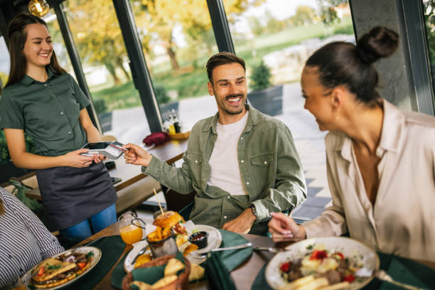 istock People paying with contactless credit card in a restaurant. 2182910781