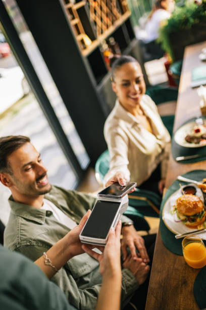 istock People paying with contactless credit card in a restaurant. 2182911273