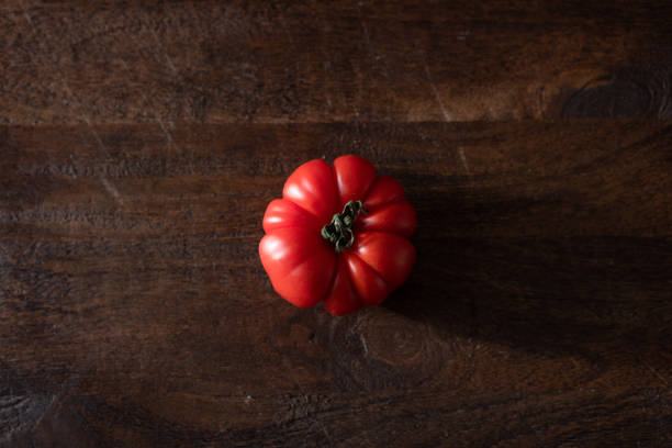 istock One fresh red tomato on a wooden surface in a dark light 2182921643