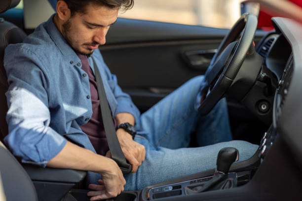 istock Young man wearing his seat belt while driving 2182924435