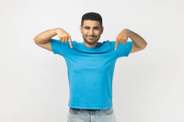 istock Smiling happy friendly man pointing down with both fingers, showing copy space for advertisement. 2182926032