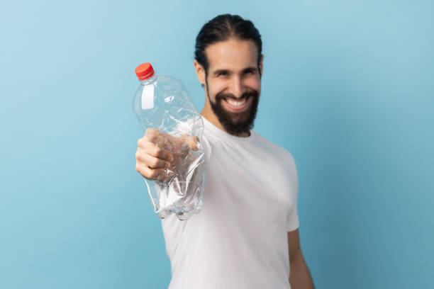 istock Man holding out plastic bottle, worrying about plastic recycling, environmental pollution. 2182926143