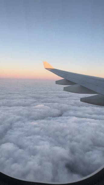 istock aeroplane wing flying over clouds with sunrise 2182927725