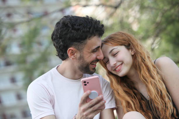 istock young couple using cellphone outdoors 2182929234