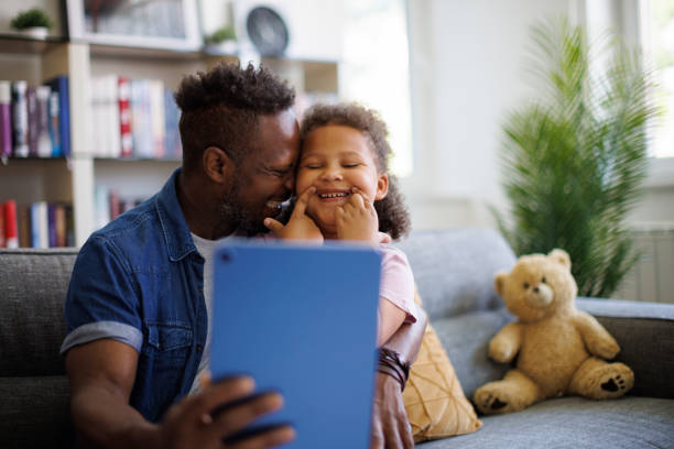 istock Father and daughter are having fun on a tablet at home 2182931592