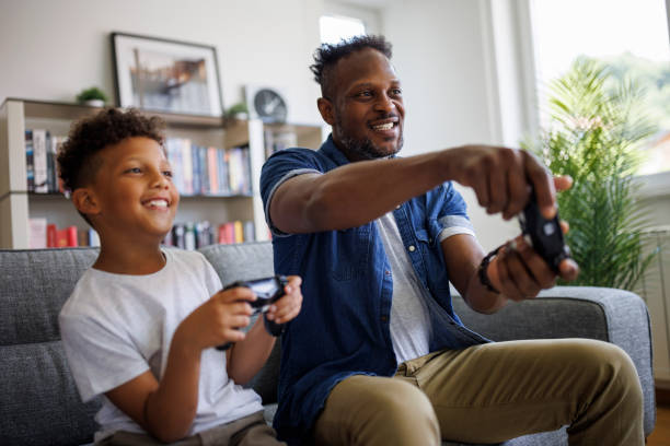 istock Father and son playing video games at home 2182931684