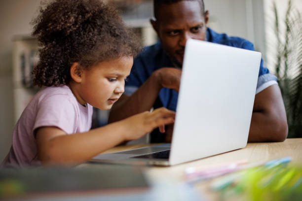istock Father and his cute daughter using laptop at home 2182931851