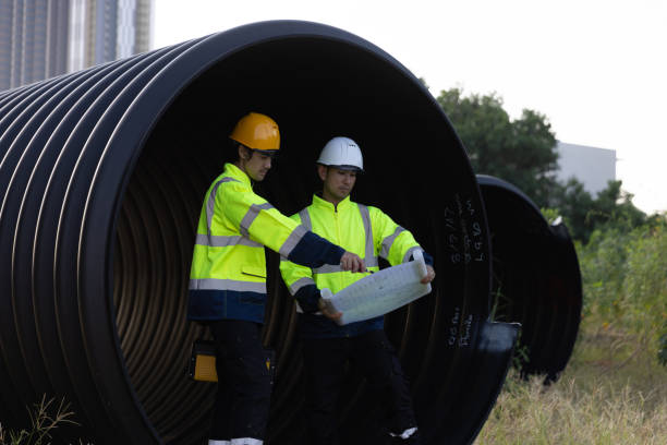 istock The maintenance engineer and construction engineer are planning and inspecting materials for a large drainage pipe and reviewing the progress of the new road construction project downtown. 2182936085