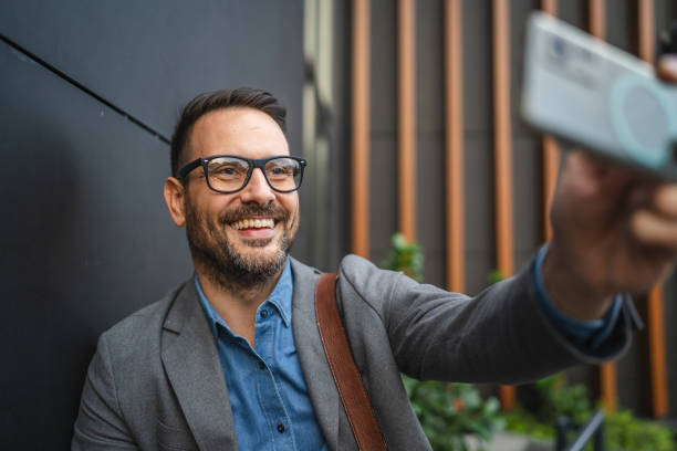 istock businessman have video call on mobile phone in front modern building 2182940008