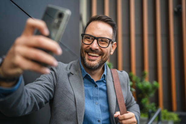 istock businessman have video call on mobile phone in front modern building 2182940018