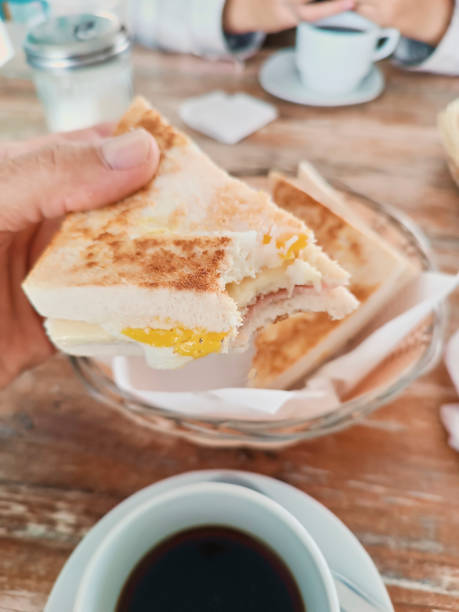istock Traditional breakfast with egg and ham sandwich and coffee 2182941804