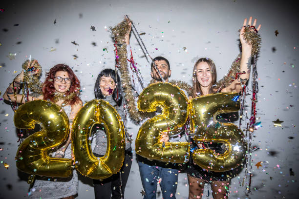 istock Festive group celebrating with 2025 balloons and confetti joy. 2182943089