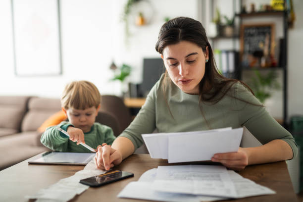 Single mother calculating family budget.