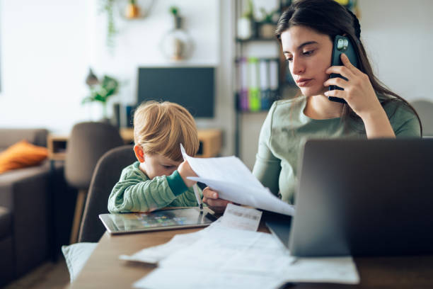 istock Single mother holding taxed documents and talking on the phone. 2182944415