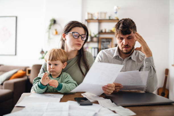 Young family managing budget and paying bills and taxes. Young family of three with a toddler managing their budget,paying bills and taxes online and calculating monthly expenses at home.Inflation concept. critical thinking kids stock pictures, royalty-free photos & images