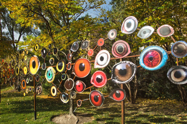 Closeup of an art installation by Jenny Kendler entitled “Birds Watching” beside the Bloomingdale Trail, aka The 606, passing through a grove of colorful trees on a sunny day in Chicago, IL