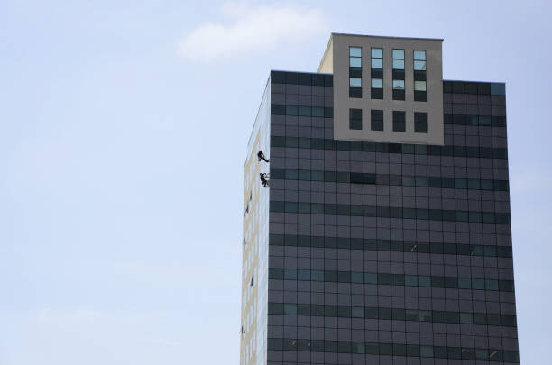 istock Workers at height cleaning the windows of the building 2182947174