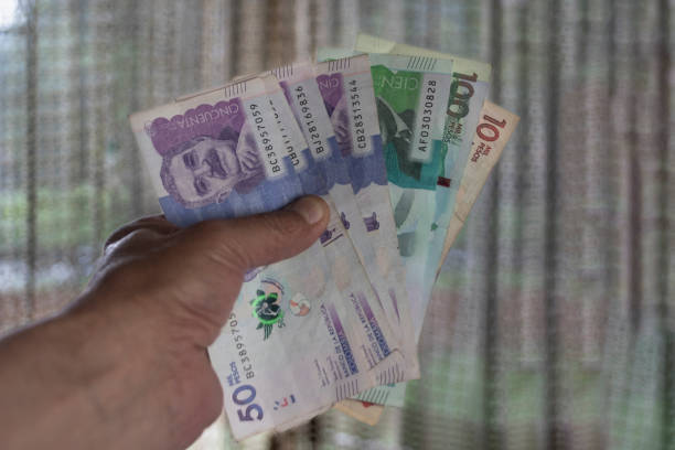 istock Colombian pesos in one hand 2182950095