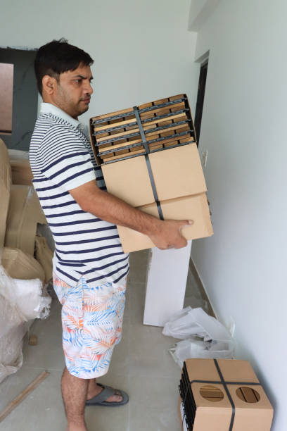 istock Image of man carrying heavy timber boxes / struggling with bad back, wooden decking squares, moving parcels as courier 2182950677