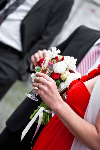 istock A bride in elegant attire toasts with a vibrant bouquet at her wedding celebration 2182958675