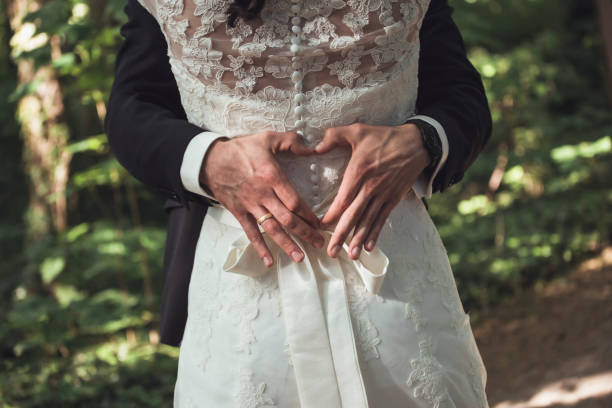 istock A couple forms a heart as they celebrate their wedding in a lush forest 2182966839
