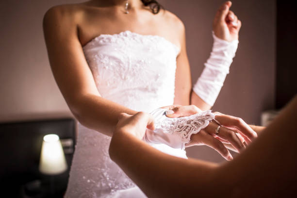 istock Bride getting ready for her wedding ceremony in an elegant dress with help from a friend 2182967777