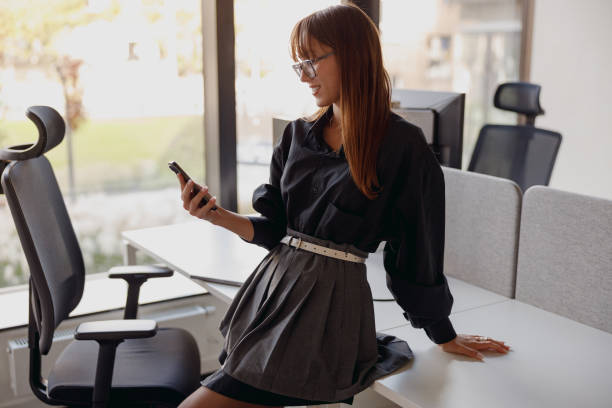 istock A young professional woman is engaged in using her smartphone within a stylish modern office space 2182968566