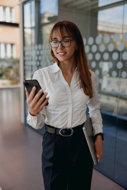 istock A confident businesswoman is using a smartphone while seated in a modern office environment 2182969235