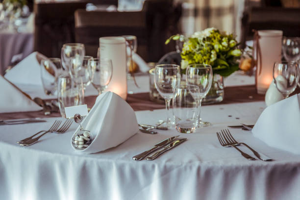 Elegant dining setup with neatly arranged tableware and floral centerpiece in a reception setting