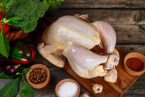istock Raw chicken is presented on cutting board, along with spices that will be used in the cooking process. 2182971479