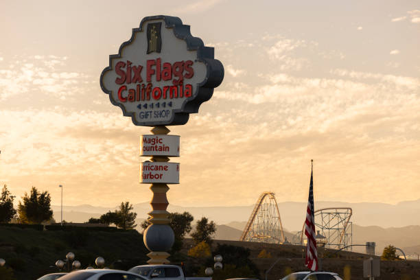 Santa Clarita, California, USA - October 24, 2024: Evening lights start to illuminate a Six Flag freeway sign as the sun sets.