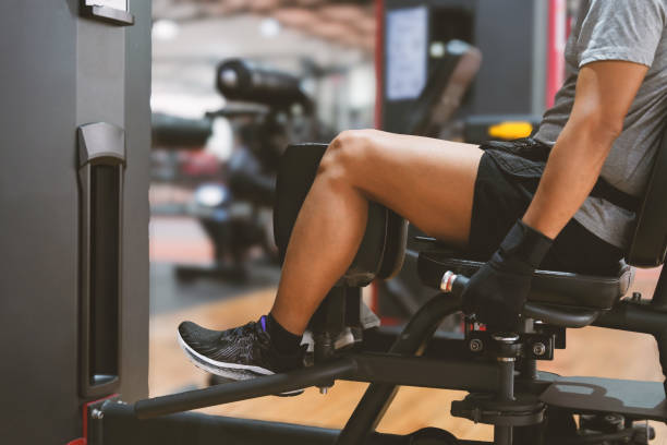 istock Man training legs in gym.   Young man doing leg extensions on machine at the gym. 2182979970