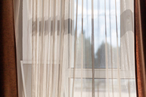 istock A window with a white curtain and a brown curtain 2182988516
