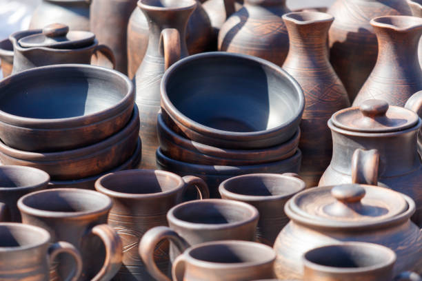 A collection of pottery, including bowls, cups, and vases, are displayed on a table