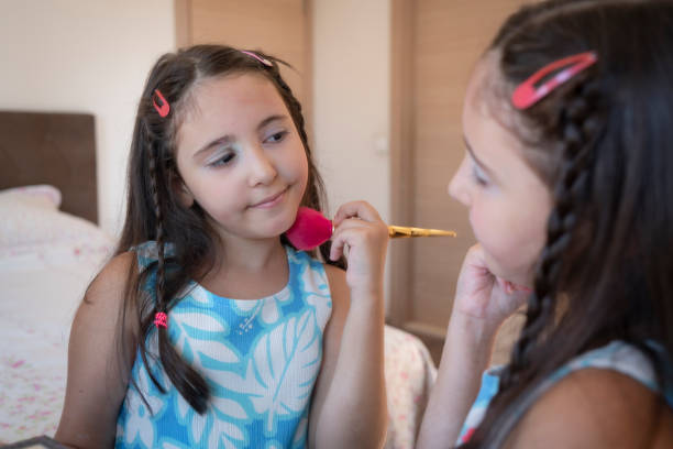 Beautiful young girl, kid applying make up with brush